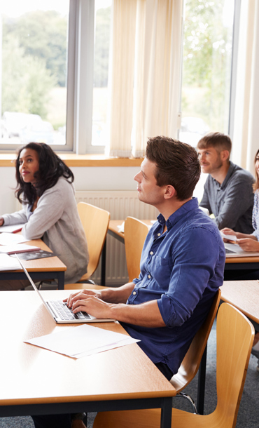 A tutor and group of adults in a classroom.