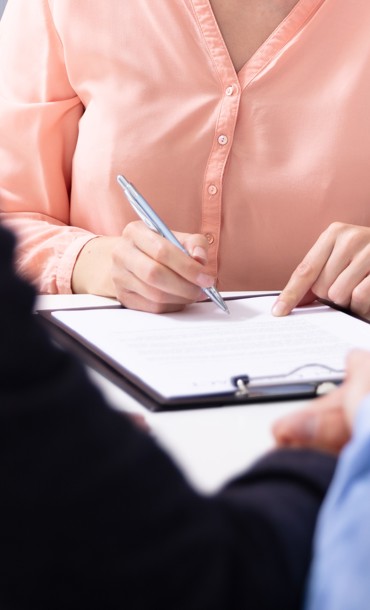 Couple meeting with a lady doing paperwork.