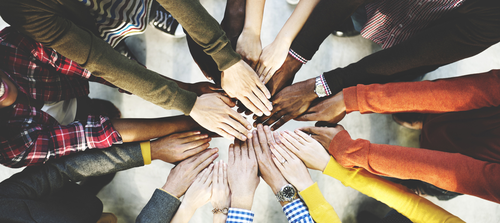 nojs From above - A group of people in a circle facing each other holding out their arms and hands.