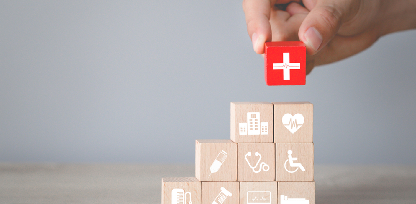 nojs Hand arranging wood block stacking with healthcare icon.