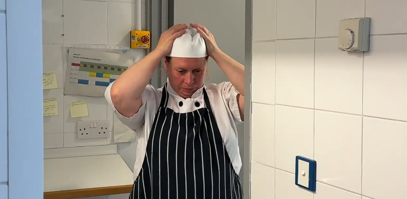 Camilla putting on her cook hat