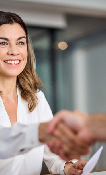 Woman at desk shaking hands