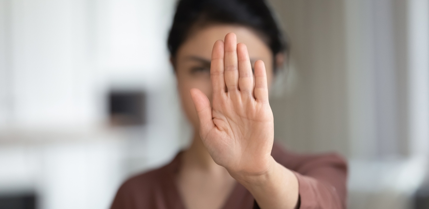 nojs Woman holding her hand in front of her face to indicate stop or no.