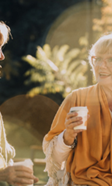 Two women sitting outside with a drink