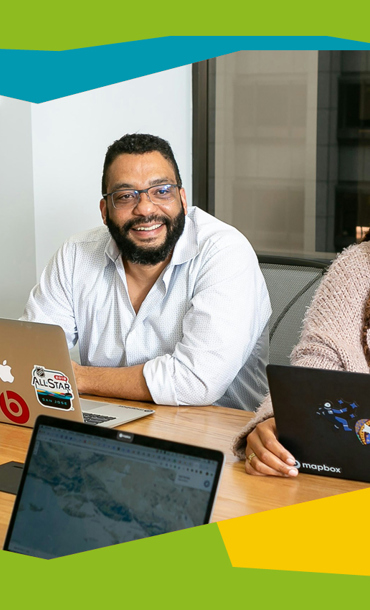 3 people with laptops looking towards the camera